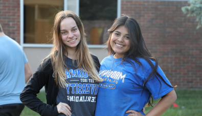 two girls smiling outside the academic building